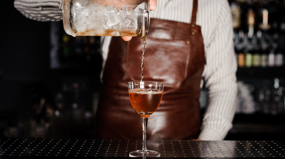 Bartender die een cocktail inschenkt 