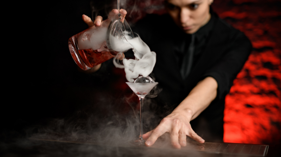 Bartender die een smokey cocktail maakt